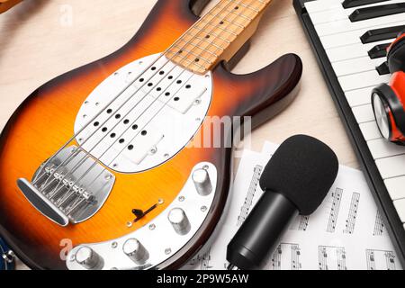Verschiedene Musikinstrumente, Kopfhörer und Mikrofon auf Holzhintergrund, Nahaufnahme Stockfoto