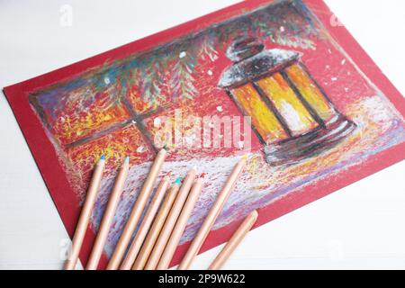 Farbenfrohe Pastellstifte und wunderschöne Malerei auf weißem Holztisch Stockfoto