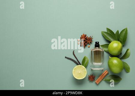 Flache Laienzusammensetzung mit einer Flasche Parfüm und frischen Zitrusfrüchten auf blassgrünem Hintergrund. Platz für Text Stockfoto