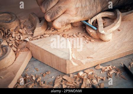 Ein Holzarbeiter, der Holz auf den Tisch schneidet. Holzarbeitertisch mit Schneidern und Werkzeugen. Zimmermann mit Meißel. Stockfoto