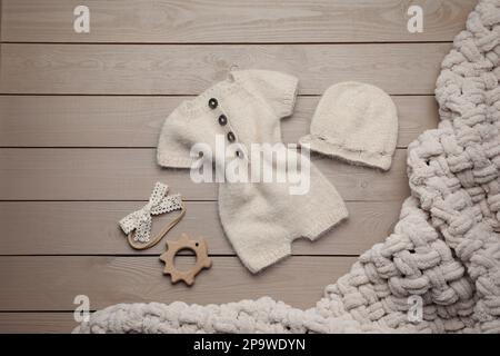 Flach liegend mit niedlicher Strickmode für Fotoaufnahmen auf Holzhintergrund Stockfoto