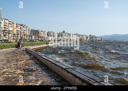 Izmir, Türkei – 5. Juni 2022. Ägäisches Ufer und Promenade im Stadtviertel Alsancak von Izmir, Türkei. Sehen Sie sich an einem stürmischen Tag mit Menschen und Wohnsitz an Stockfoto
