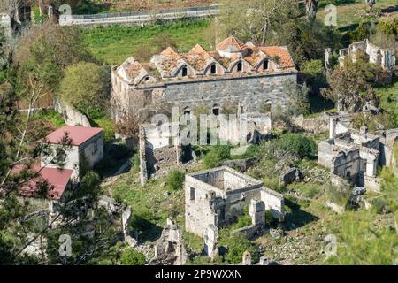 Blick über die Ruinen, einschließlich der Ruine der unteren Kataponagia-Kirche, des verlassenen Dorfes Kayakoy (Levissi) in der Nähe von Fethiye in der Provinz Mugla der Türkei. Levis Stockfoto