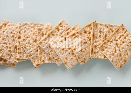 Banner von jüdischer koscherer Matzo für Passover auf blauem Hintergrund. Jüdischer Feiertag in Pesach. Blick von oben. Stockfoto