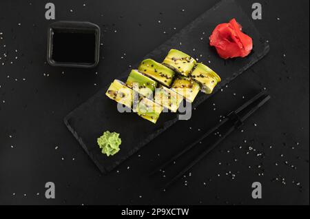 Vegetarische Sushi-Brötchen Avocado mit Philadelphia-Sahne-Käse, Sesam und Unagi-Sauce. Stockfoto