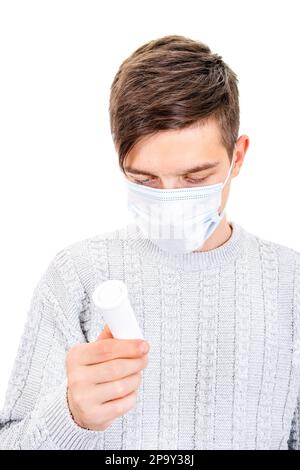 Junger Mann mit Grippemaske mit Pillen isoliert auf weißem Hintergrund Stockfoto