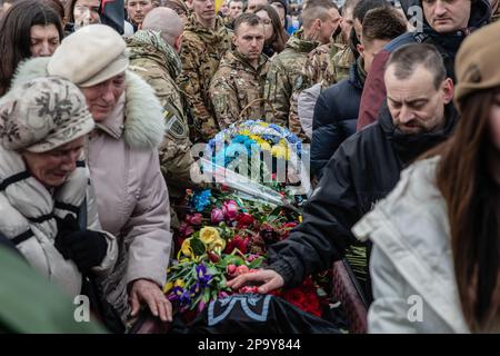 Blick auf den Sarg mit dem verstorbenen Da Vinci Hero der Ukraine, dekoriert mit Blumen und umgeben von Verwandten, Freunden und anderen Soldaten. Gedenkfeier für ukrainischen Offizier und legendären Held der Ukraine Dmytro Kotsiubaylo, Codename „Da Vinci“, am Unabhängigkeitsplatz in Kiew, Ukraine, Freitag, 10. März 2023. Kotsiubaylo wurde vor drei Tagen in einer Schlacht nahe Bakhmut in der Donezk-Region getötet. Tausende kamen, um Da Vinci die letzte Ehre zu erweisen. Insbesondere ist Präsident Wladimir Zelenski gekommen, um dem Helden seine letzte Ehre zu erweisen. Stockfoto