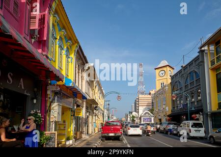 Farbenfrohe Geschäfte im chinesisch-portugiesischen Stil in der Phang-Nga Rd In der Altstadt von Phuket Town, Thailand, mit dem berühmten Phromthep Clocktower in b/g Stockfoto
