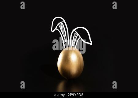 Frohe Ostern, Kaninchenohren, goldene Eier. Stockfoto