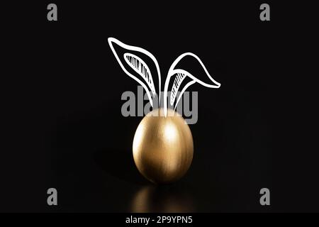 Frohe Ostern, Kaninchenohren, goldene Eier. Stockfoto