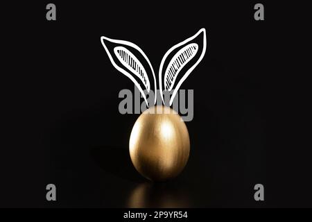 Frohe Ostern, Kaninchenohren, goldene Eier. Stockfoto