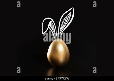 Frohe Ostern, Kaninchenohren, goldene Eier. Stockfoto