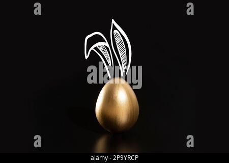 Frohe Ostern, Kaninchenohren, goldene Eier. Stockfoto