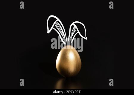 Frohe Ostern, Kaninchenohren, goldene Eier. Stockfoto