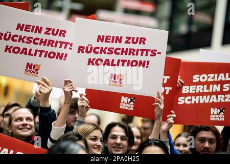 Berlin, Deutschland. 11. März 2023. Die Delegierten halten Schilder mit der Aufschrift "Soziales Berlin statt Schwarz und Rot" und "Nein zu einer regressiven Koalition" am Rande der Konferenz der Staatsdelegierten von Jusos Berlin im Willy-Brandt-Haus hoch. Auf der eintägigen Konferenz wollen die Jusos über die aktuelle politische Situation in Berlin und die Koalitionsverhandlungen mit der CDU sprechen. Kredit: Fabian Sommer/dpa/Alamy Live News Stockfoto