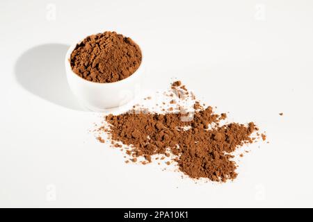 Kakaopulver in weißer Schüssel оn weißem Hintergrund. Stockfoto