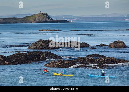 North Berwick, East Lothian, Schottland, Großbritannien. 11. märz 2023 Sonnenschein segnete das Meer für diejenigen, die am Strand unterwegs sind und das Wasser mit einer kühlen Temperatur von 4 Grad Celsius. Abbildung: Kajaks im Vordergrund mit der Insel Fidra mit ihrem Leuchtturm im Hintergrund. Stockfoto