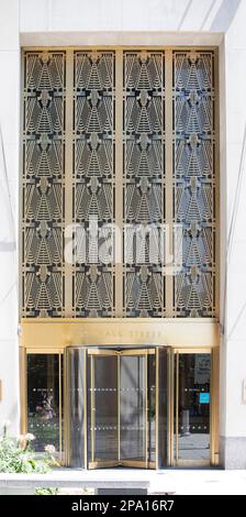 NYC Financial District: Eingang aus poliertem Messing an der Wall Street 120, auf einer fünfstöckigen Steinbasis gelegen. Ein ähnlicher, kürzerer Eingang ist auf der South Street. Stockfoto