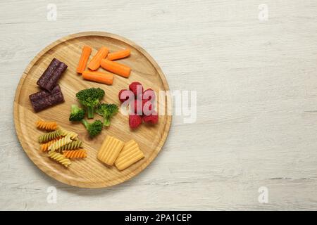 Gehen Sie an Bord mit verschiedenen köstlichen Fingerfood für Babys auf einem Holztisch, Draufsicht. Platz für Text Stockfoto