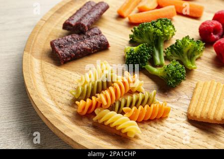 Holzbrett mit verschiedenen Fingerfood für Babys auf dem Tisch, Nahaufnahme Stockfoto