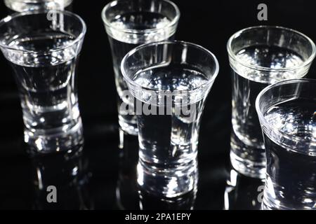 Schnapsgläser mit Wodka auf schwarzem Tisch Stockfoto