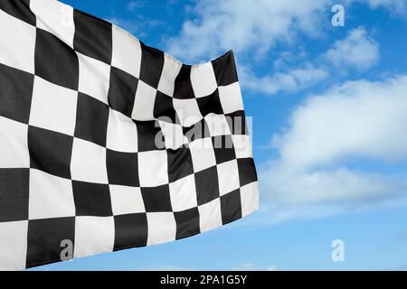 Die Zielflagge mit Karomuster vor blauem Himmel Stockfoto