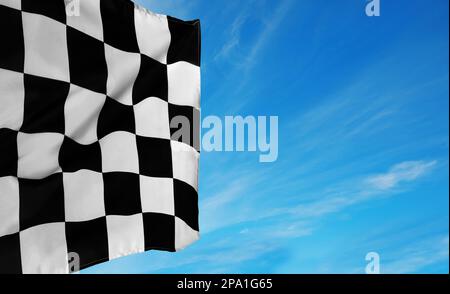 Die Zielflagge mit Karomuster vor blauem Himmel. Platz für Text Stockfoto