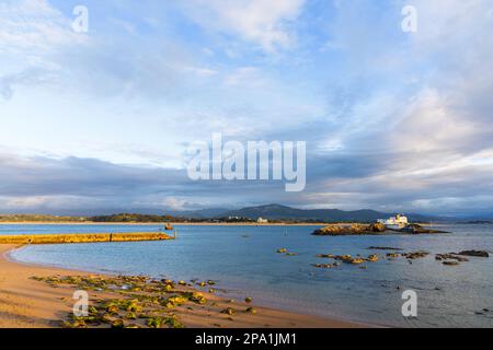 Abendlicher Blick auf den Bikini-Strand (Playa de los Bikinis) auf der Magdalena-Halbinsel und der Bucht von Santander mit goldenem Sand und Felsen. Santander, Stockfoto