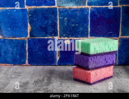 Waschschwämme auf blauen Badezimmerfliesen gestapelt. Bannerhintergrund mit Kopierbereich für Text. Stockfoto