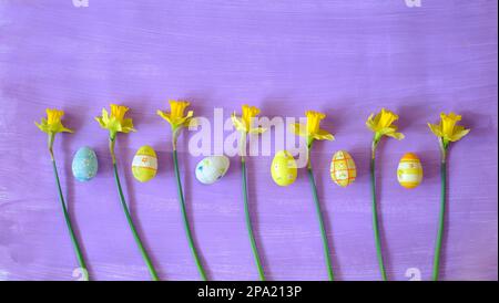 osterdekoration mit handbemalten ostereiern und Narzissenblumen, flach liegend Stockfoto
