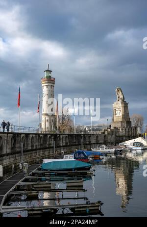 Löwenpier mit Booten und bayerischem Löwen, im hinteren Leuchtturm von New Lindau, Eingang zum Hafen von Lindau, Insel Lindau, Bodensee, Bayern, Deutschland Stockfoto