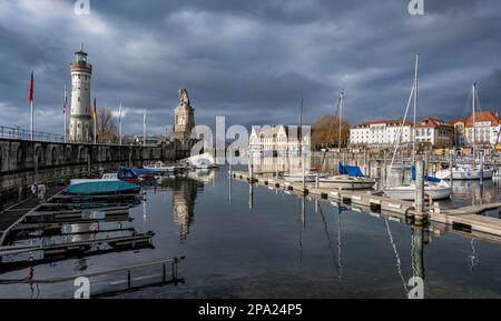 Hafeneingang des Hafens von Lindau, Anlegestelle mit Booten am Pier mit dem Leuchtturm von New Lindau und dem bayrischen Löwen, Lindau Island, Bodensee Stockfoto