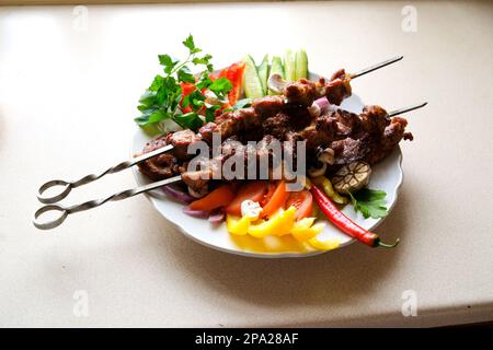 Das wichtigste Fleischgericht der türkischen Küche Kebabs ist ein reichhaltiges Produkt, das auf Glut gekocht wird Shish Kebab mit Pilzen, Kirschtomaten und süßem Pfeffer, gegrillte Fleischspieße. Draufsicht, Kopierraum Stockfoto