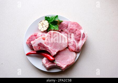 Verschiedene klassische, alternative rohe Fleischsorten, Rindfleisch-Steaks Chateau Mignon, T-Bone, Tomahawk, Striploin, Filet, New yorker Steak. Flache Draufsicht auf weißem Tischhintergrund. Hochwertiges Foto Stockfoto