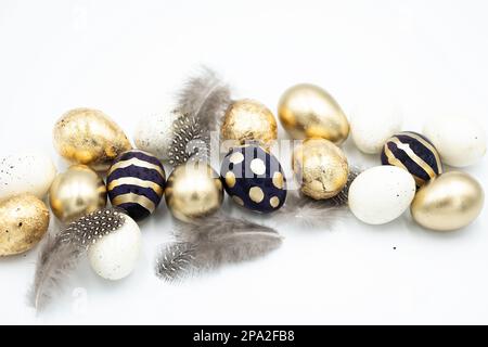 Goldene und schwarze Ostereier, Feder. Stockfoto
