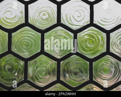 Buntglasfenster mit Sechskantküvetten und geripptem Milchglas. Detail des Fensters, selektiver Fokus Stockfoto