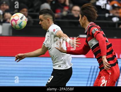 11. März 2023, Hessen, Frankfurt/Main: Fußball: Bundesliga, Eintracht Frankfurt - VfB Stuttgart, Spieltag 24 im Deutsche Bank Park. Rafael Santos Borré (l) in Frankfurt und Hiroki Ito in Stuttgart kämpfen um den Ball. Foto: Arne Dedert/dpa - WICHTIGER HINWEIS: Gemäß den Anforderungen der DFL Deutsche Fußball Liga und des DFB Deutscher Fußball-Bund ist es verboten, im Stadion aufgenommene Fotografien und/oder das Spiel in Form von Sequenzbildern und/oder videoähnlichen Fotoserien zu verwenden oder verwenden zu lassen. Stockfoto