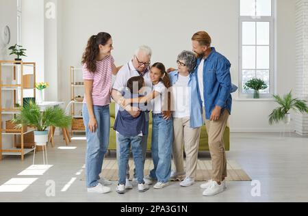 Große, freundliche Familie, von der jüngsten Generation bis zu den ältesten Umarmungen und Freuden, wenn Sie sich zu Hause treffen. Stockfoto