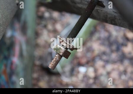 Eine Nahaufnahme eines alten verrosteten Bolzens mit Mutter darauf. Stockfoto