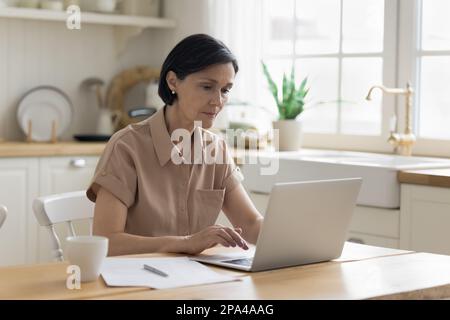Fokussierte, freiberufliche Frau, die von zu Hause aus arbeitet Stockfoto