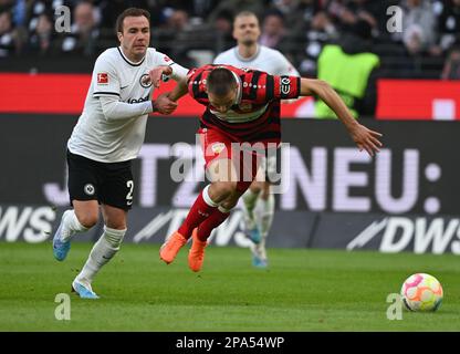 11. März 2023, Hessen, Frankfurt/Main: Fußball: Bundesliga, Eintracht Frankfurt - VfB Stuttgart, Spieltag 24 im Deutsche Bank Park. Mario Götze (l) in Frankfurt und Waldemar Anton in Stuttgart kämpfen um den Ball. Foto: Arne Dedert/dpa - WICHTIGER HINWEIS: Gemäß den Anforderungen der DFL Deutsche Fußball Liga und des DFB Deutscher Fußball-Bund ist es verboten, im Stadion aufgenommene Fotografien und/oder das Spiel in Form von Sequenzbildern und/oder videoähnlichen Fotoserien zu verwenden oder verwenden zu lassen. Stockfoto