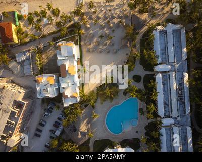 Schüsse von einer Drohne. Resort-Hotel. An der sandigen Küste gibt es viel tropisches Grün, die Dächer von Hotels, kleine Häuser, Autos. Tourismus, Nachteile Stockfoto