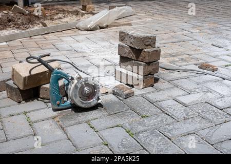 Kleine Betonsäge neben Steinblöcken an einem sonnigen Tag. Stockfoto