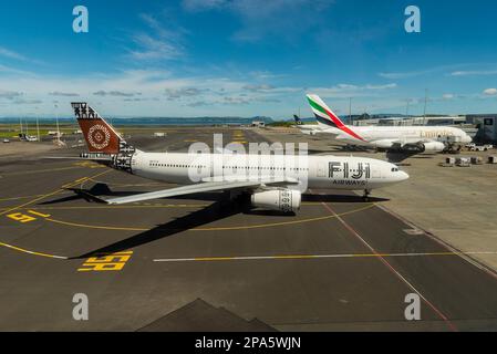 Fidschi Airways Airbus A330 Airliner Jet Flugzeug DQ-FJV Taxifahrt zum Stand am Auckland Airport, Neuseeland, von Emirates A380 A6-EVR. Flugreisen im Pazifik Stockfoto