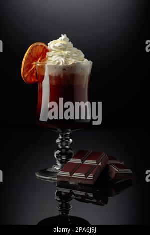 Schokoladencocktail mit Schlagsahne, garniert mit einer getrockneten Orangenscheibe. Stockfoto