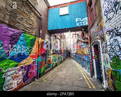 Farbenfrohe, mit Graffiti bedeckte Wände einer engen Gasse in der Nähe der Corn Street in der Altstadt von Bristol UK Stockfoto