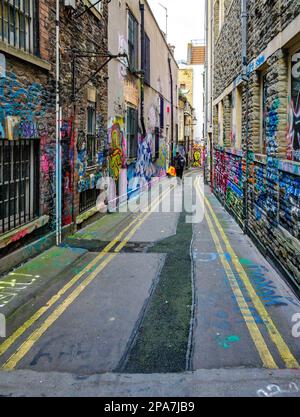 Farbenfrohe, mit Graffiti bedeckte Wände einer engen Gasse in der Nähe der Corn Street in der Altstadt von Bristol UK Stockfoto