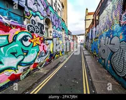 Graffiti-bedeckte Wände einer engen Gasse in der Gegend von Stokes Croft in Bristol UK Stockfoto