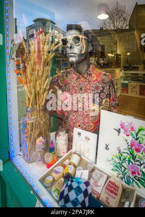 Souvenirladen-Fenster in einer Bristol UK Straße mit coolen Schaufensterpuppen in Sonnenschirmen Stockfoto