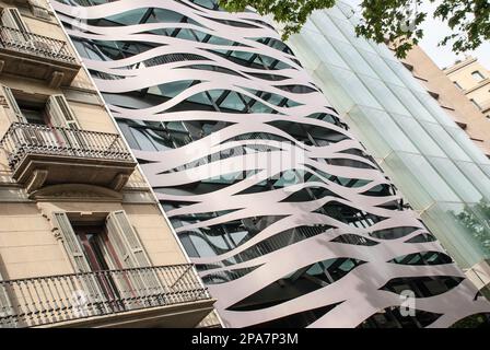 Modernes avantgardistisches Gebäude gegenüber Gaudis La Pedrera, möglicherweise luxuriöse Apartments, Suites Avenue Hotel. Es ist das Alte im Vergleich zum Neuen. Stockfoto